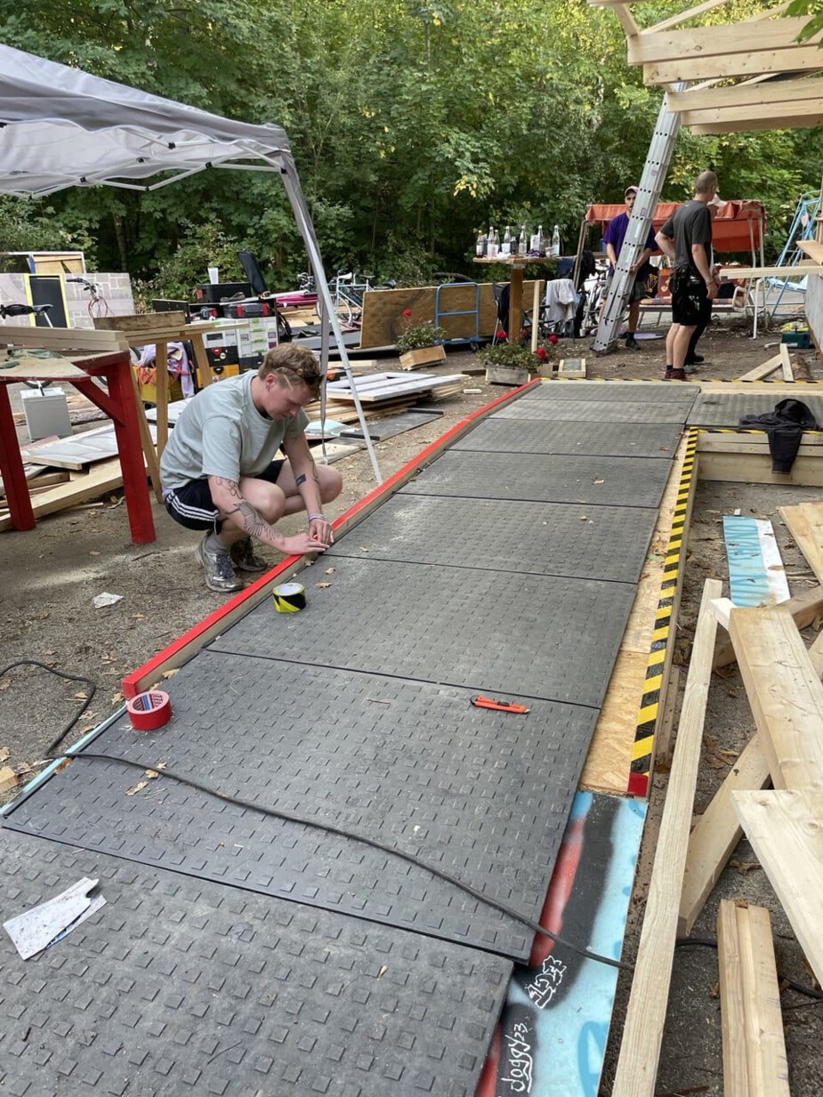 The edges of the ramp and platform are clearly marked by a person using striped adhesive tape.