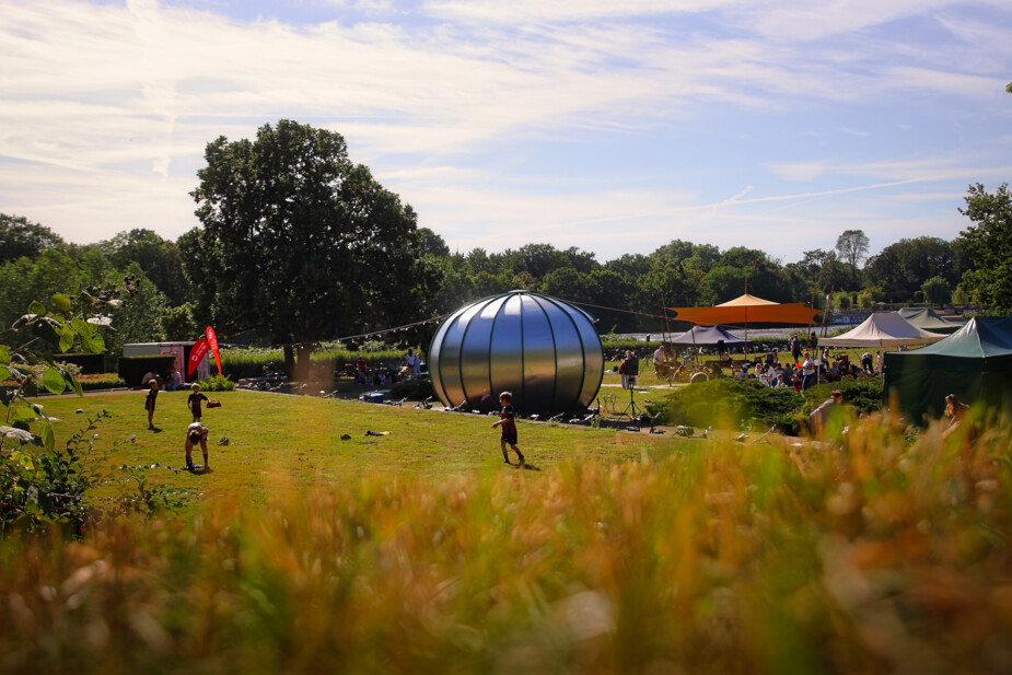 Kinder spielen auf der Wiese hinter der Bühne